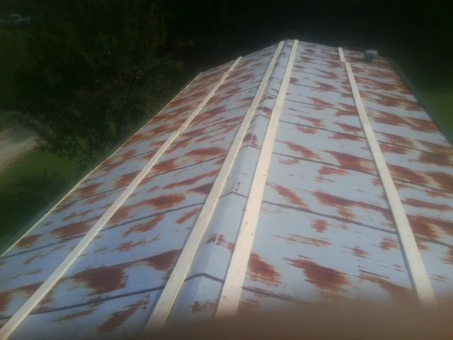 Rusted metal roof panels with new wood purlins before replacement — Storm Damage Roof Repair in Orange Park by Roofing Brothers