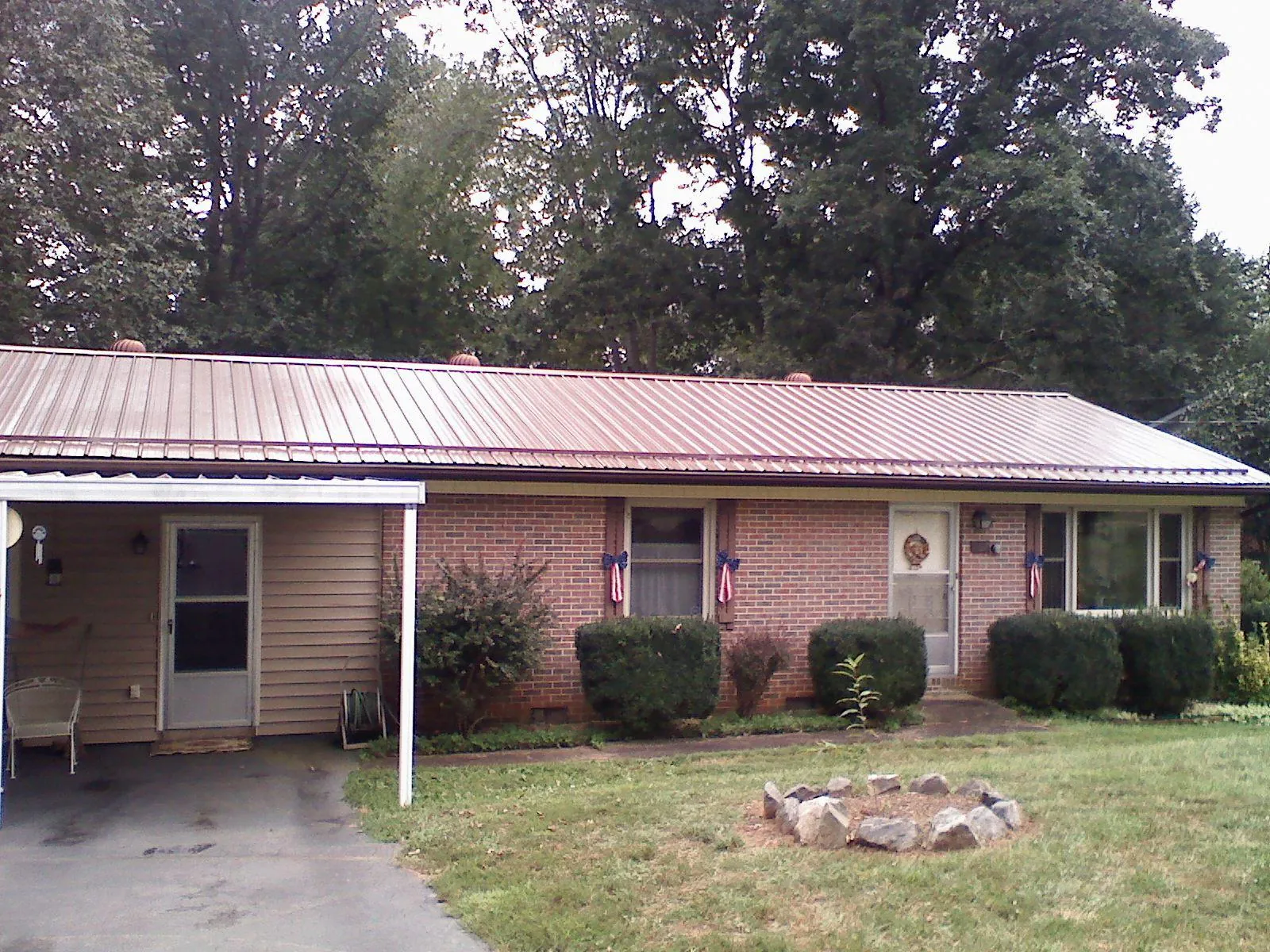 Bronze metal roof and carport on a brick ranch home — Roof Repair work by our crew in Orange Park
